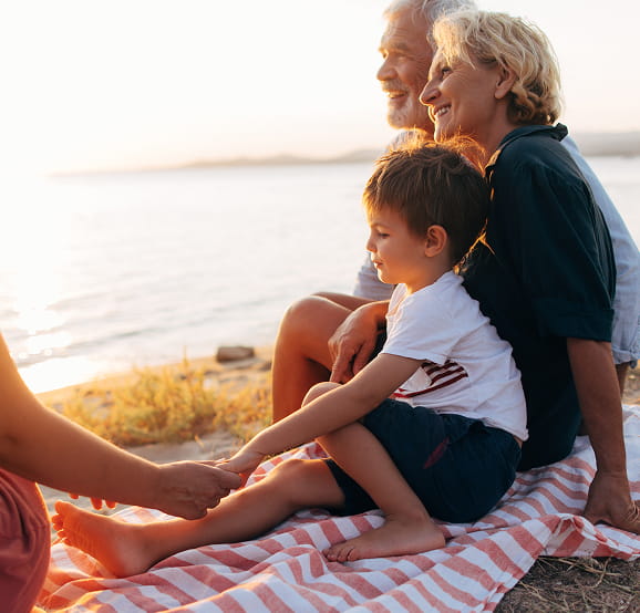 Family enjoying a peaceful moment together by the water at sunset